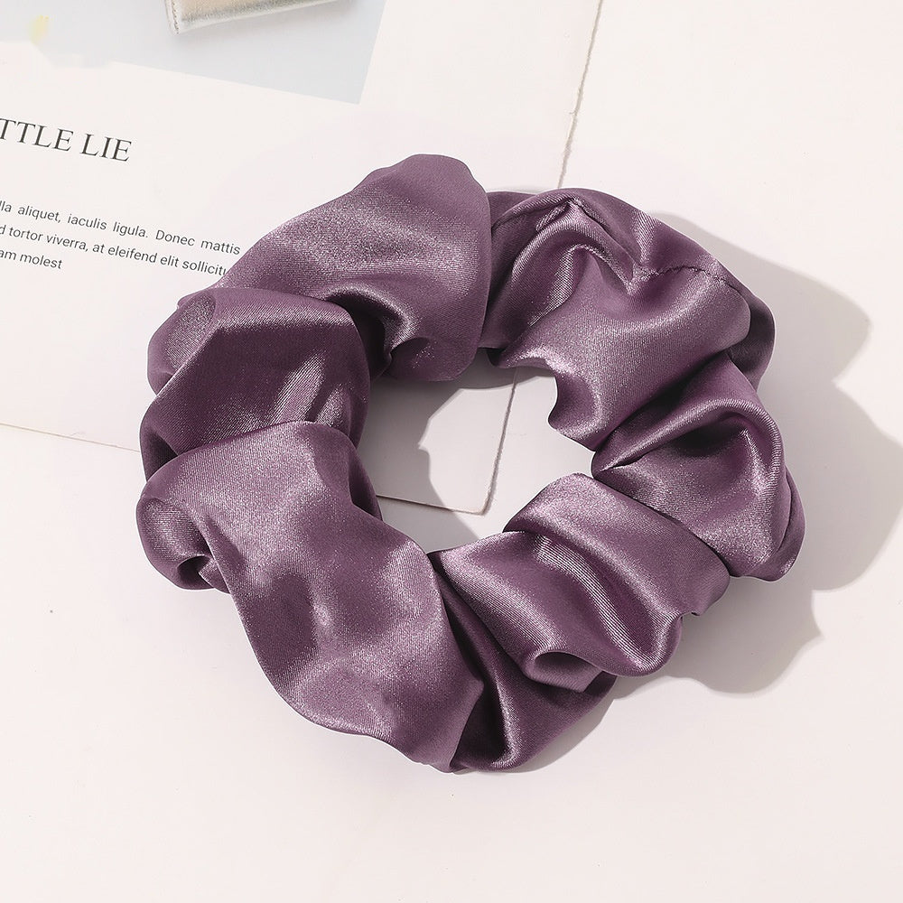Chouchou en satin de soie violet posé sur une table