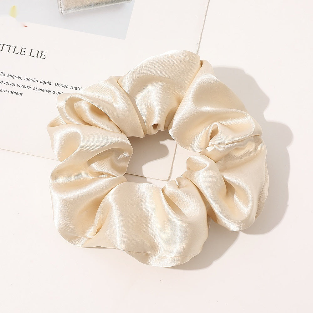 Chouchou en satin de soie beige clair, classe et confortable sur une table